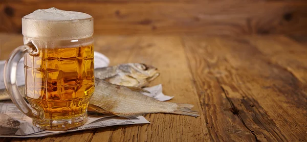 Beer and dried fish on wooden table — Stock Photo, Image