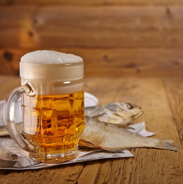 Beer and dried fish on wooden table — Stock Photo, Image