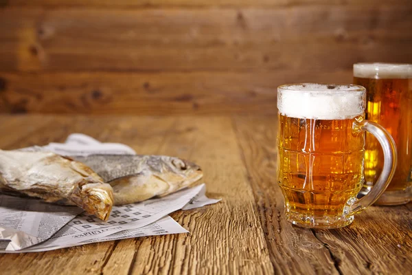 Birra e pesce secco sul tavolo di legno — Foto Stock