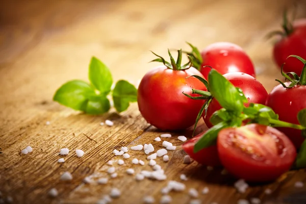 Tomatoes lying on old table — Stock Photo, Image