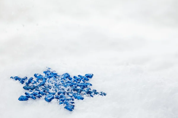 Blaue Schneeflocke auf Schnee — Stockfoto