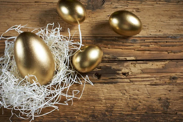 Goldene Eier im Nest auf dunkel — Stockfoto