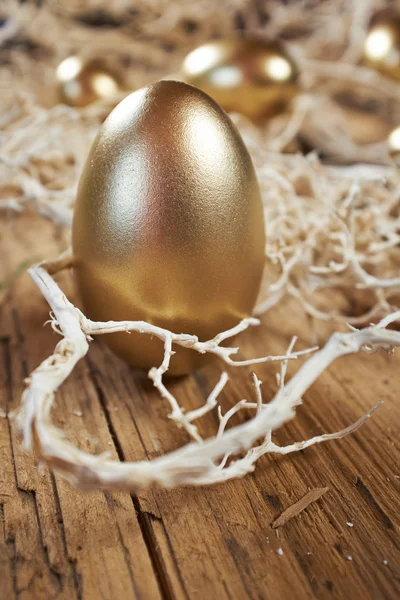 Золотые яйца в гнезде в темноте — стоковое фото