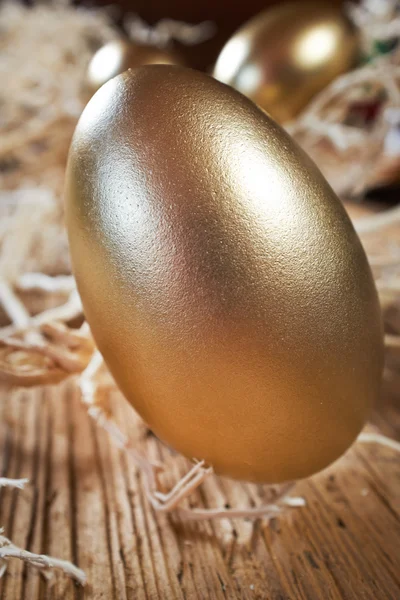 Golden eggs in nest on dark — Stock Photo, Image