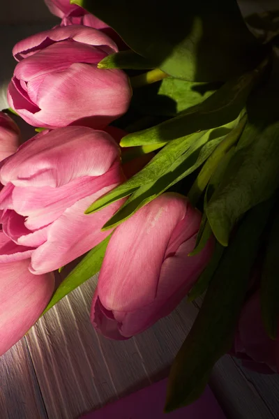 Pink tulips over  wooden table — Stock Photo, Image