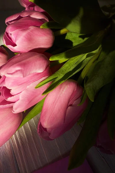 Tulipas cor-de-rosa sobre mesa de madeira — Fotografia de Stock