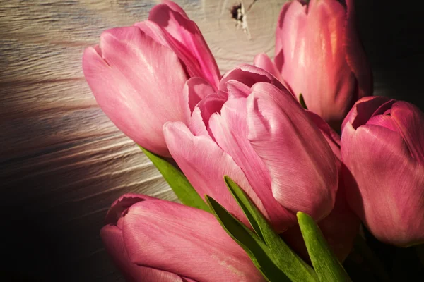 Růžové tulipány dřevěný stůl — Stock fotografie