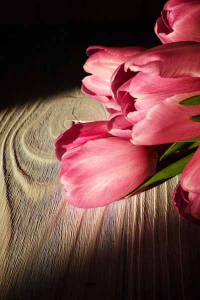 Ροζ τουλίπες πέρα από το ξύλινο τραπέζι — Φωτογραφία Αρχείου