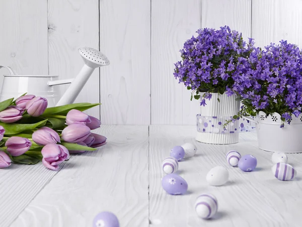 Ovos de Páscoa de cor pastel com tulipas na mesa — Fotografia de Stock