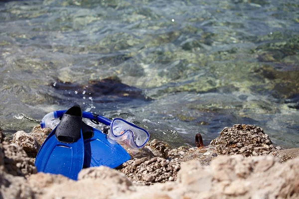 Masker en flippers op een rots strand — Stockfoto