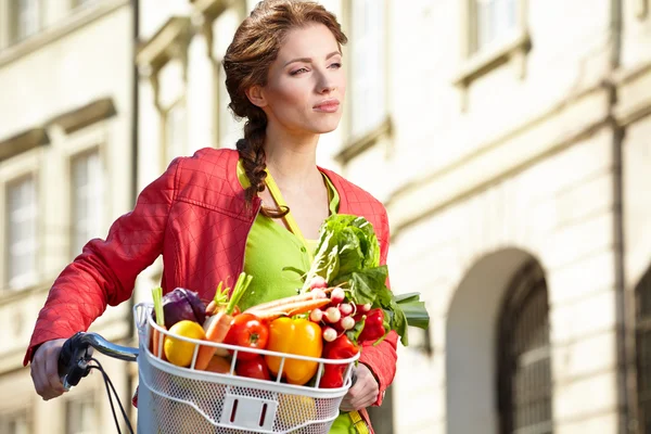 Frau mit Fahrrad und Lebensmitteln — Stockfoto