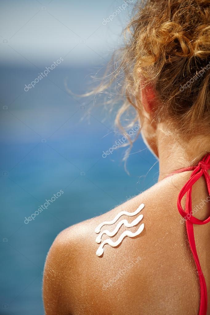 Woman With Suntan Lotion At The Beach — Stock Photo © zoomteam 65436363