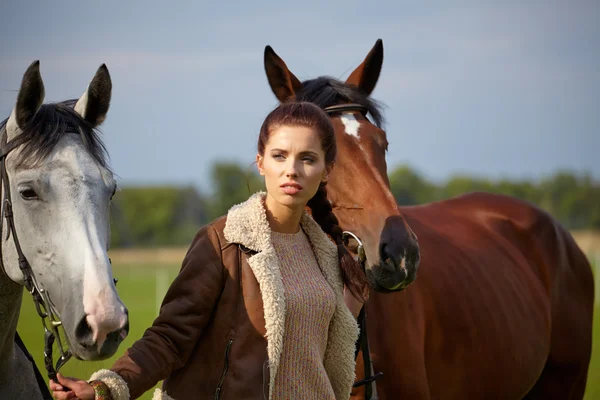 Vacker kvinna och två hästar utomhus — Stockfoto