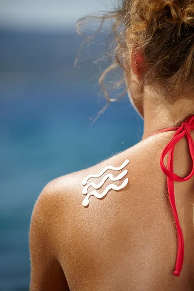 Meisje terug met zonnebrand en zon lotion — Stockfoto