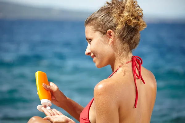 Mujer aplicando crema solar protector solar — Foto de Stock