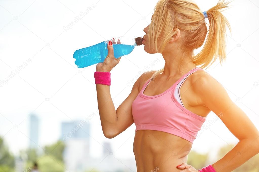 Woman drinking water after training