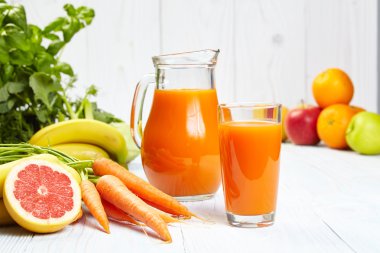 Havuç suyu Beyaz ahşap masa üzerinde