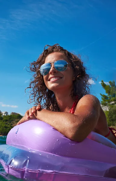 Menina flutuando em um colchão — Fotografia de Stock