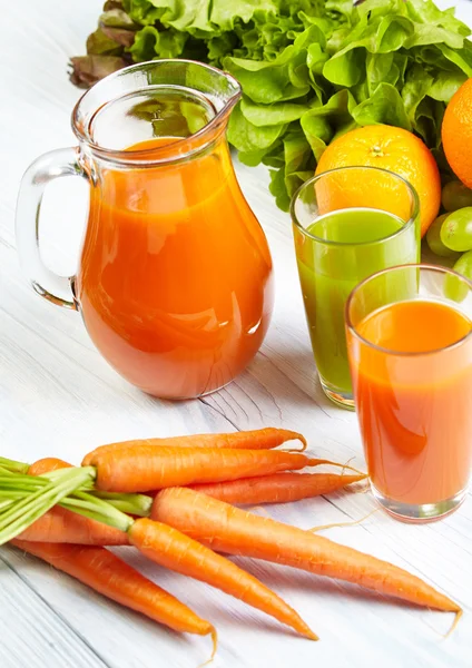 Carrot juice on white wood table — Stock Photo, Image