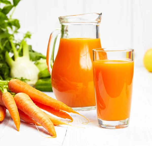 Carrot juice on white wood table — Stock Photo, Image