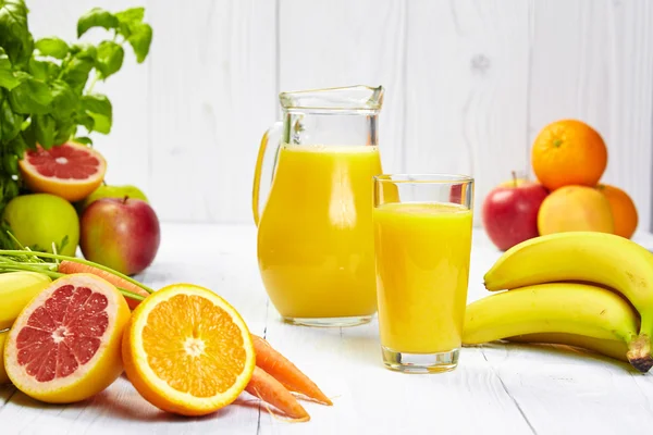 Vaso lleno y jarra de jugo de plátano — Foto de Stock