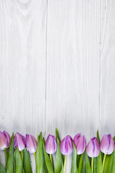 Pink tulips over wooden table — Stock Photo, Image