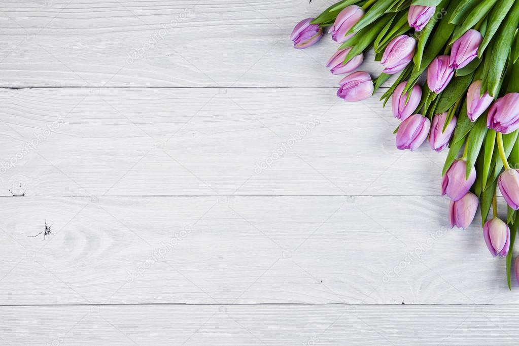 Pink tulips over wooden table