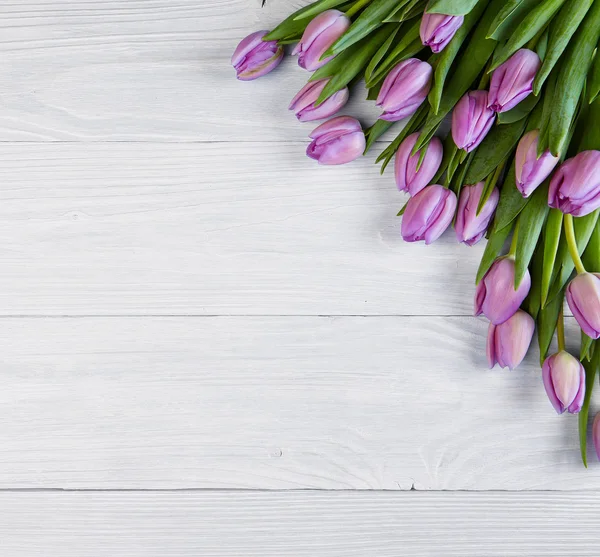 Tulips over shabby wooden table — Stock Photo, Image