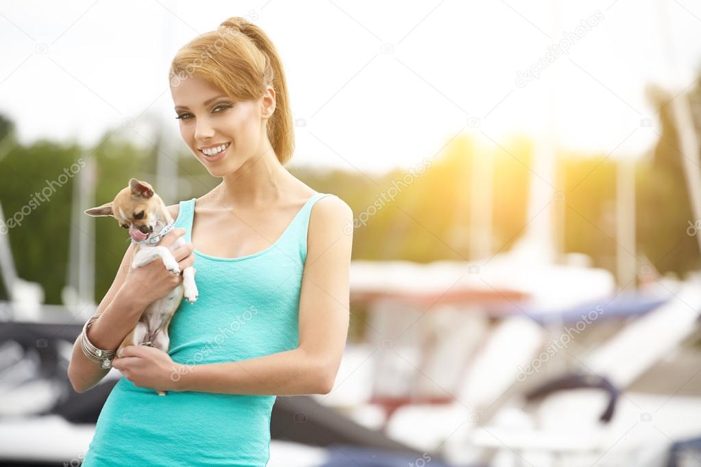 Woman with dog near the boats and yachts