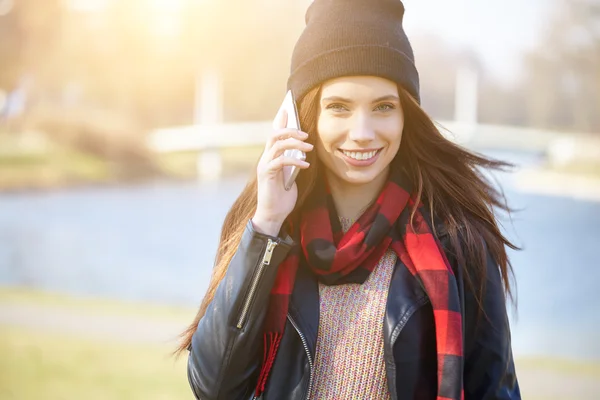 Menina usando um boné falando em um telefone celular — Fotografia de Stock