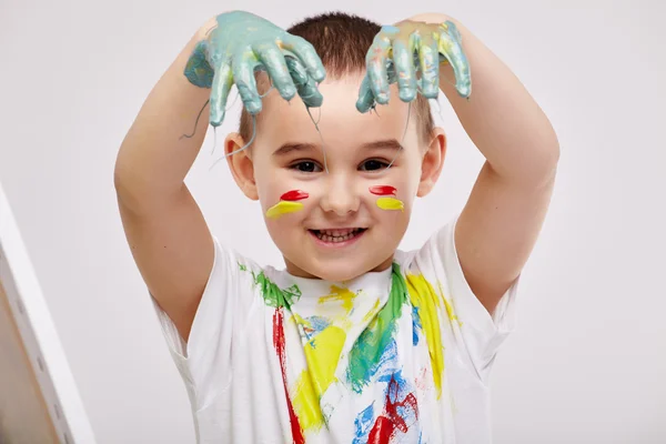 Garçon avec les mains peintes dans des peintures colorées — Photo