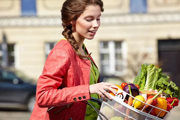 Vrouw met fiets en boodschappen — Stockfoto