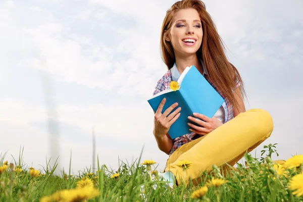 Mulher no campo verde e livro de leitura — Fotografia de Stock