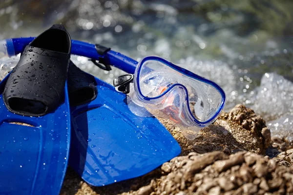 Mask and flippers on a rock beach — Stock Photo, Image