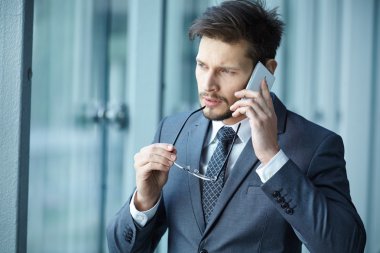 hareket eden telefon ofis lobisinde konuşurken işadamı
