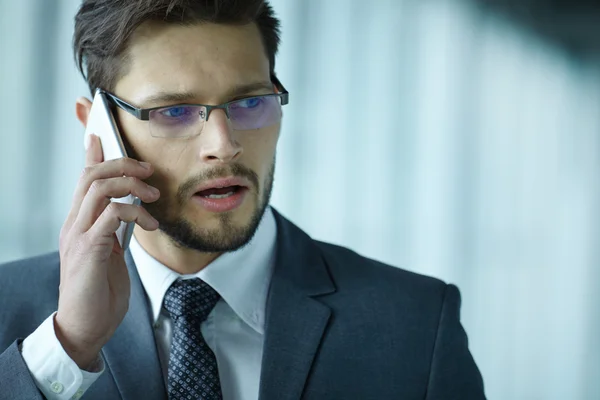 Empresario hablando por teléfono móvil en el vestíbulo de la oficina — Foto de Stock