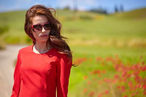 Женщина в красном платье на маковом поле — стоковое фото