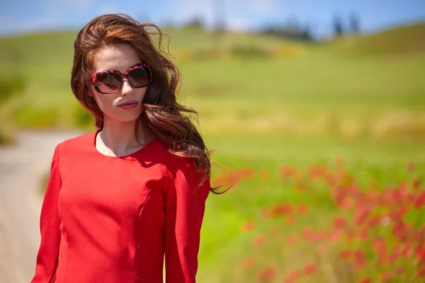 Donna in abito rosso in un campo di papaveri — Foto Stock