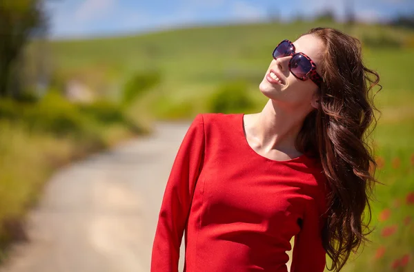 Mujer en vestido rojo en un campo de amapola — Foto de Stock