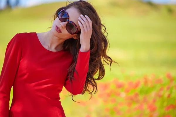 Frau in rotem Kleid in einem Mohnfeld — Stockfoto