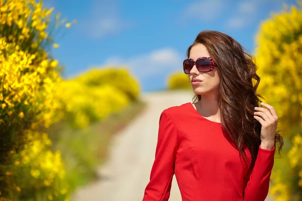 Kırsal bir yolda kırmızı giysili bir kadına — Stok fotoğraf