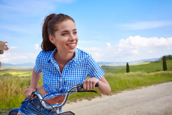 Mulher com bicicleta vintage em uma estrada rural — Fotografia de Stock