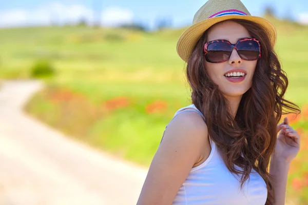 Mujer joven con amapolas en el campo —  Fotos de Stock