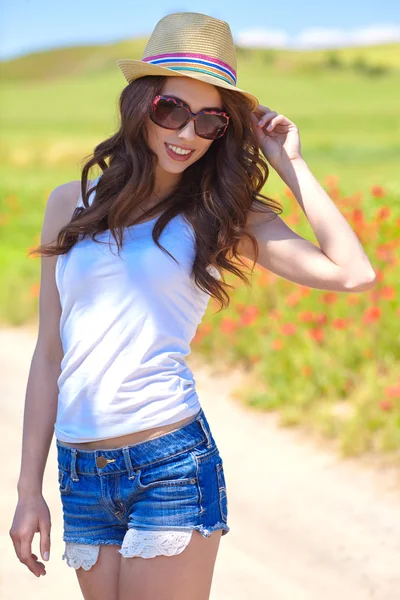 Mujer joven con amapolas en el campo —  Fotos de Stock