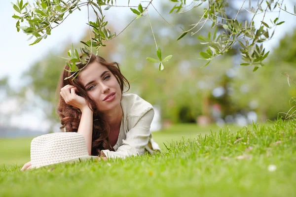 Smiling young girl lying on grass — Stock Photo, Image