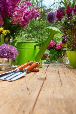 Bahçe aletleri ve terasta çiçekler