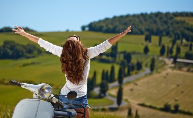 İtalyan bir scooter üzerinde oturan kadın