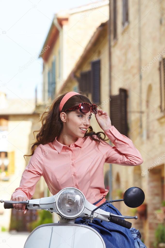 woman on a scooter on the streets of the Tuscan town