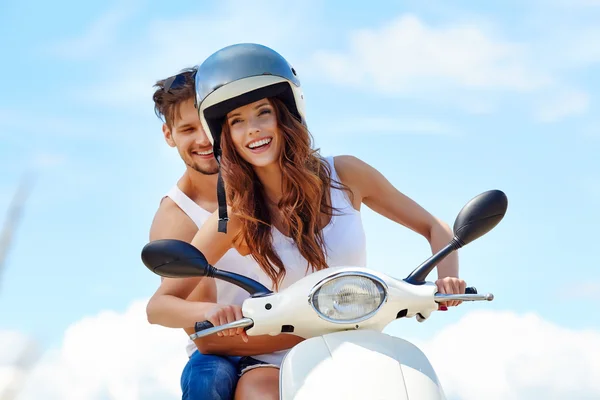 Casal apaixonado se divertindo andando em uma scooter — Fotografia de Stock