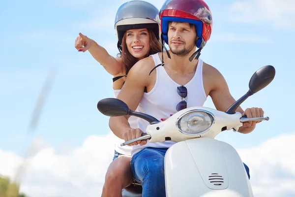 Pareja enamorada divirtiéndose cabalgando en un scooter —  Fotos de Stock